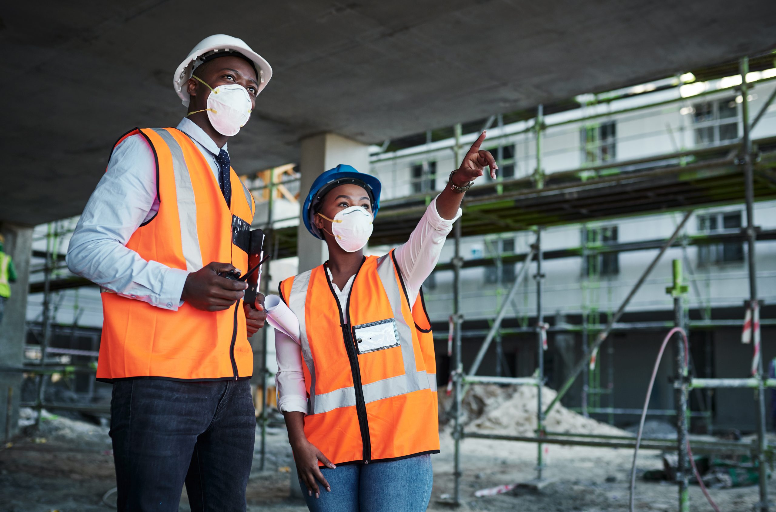 Shot of a young man and woman having a discussion while working at a construction site.